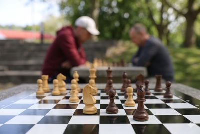Zwei Personen spielen Schach im Park